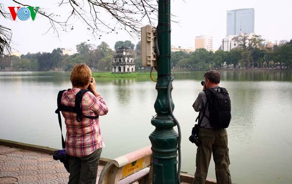 Hai khách du lịch mê mải ghi hình ảnh Tháp Rùa